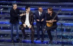 Italian singers Bresh (L), Sanremo Festival host and artistic director Carlo Conti and Cristiano De Andre' on stage at the Ariston theatre during the 75th edition of the Sanremo Italian Song Festival, in Sanremo, Italy, 14 February 2025. The music festiva