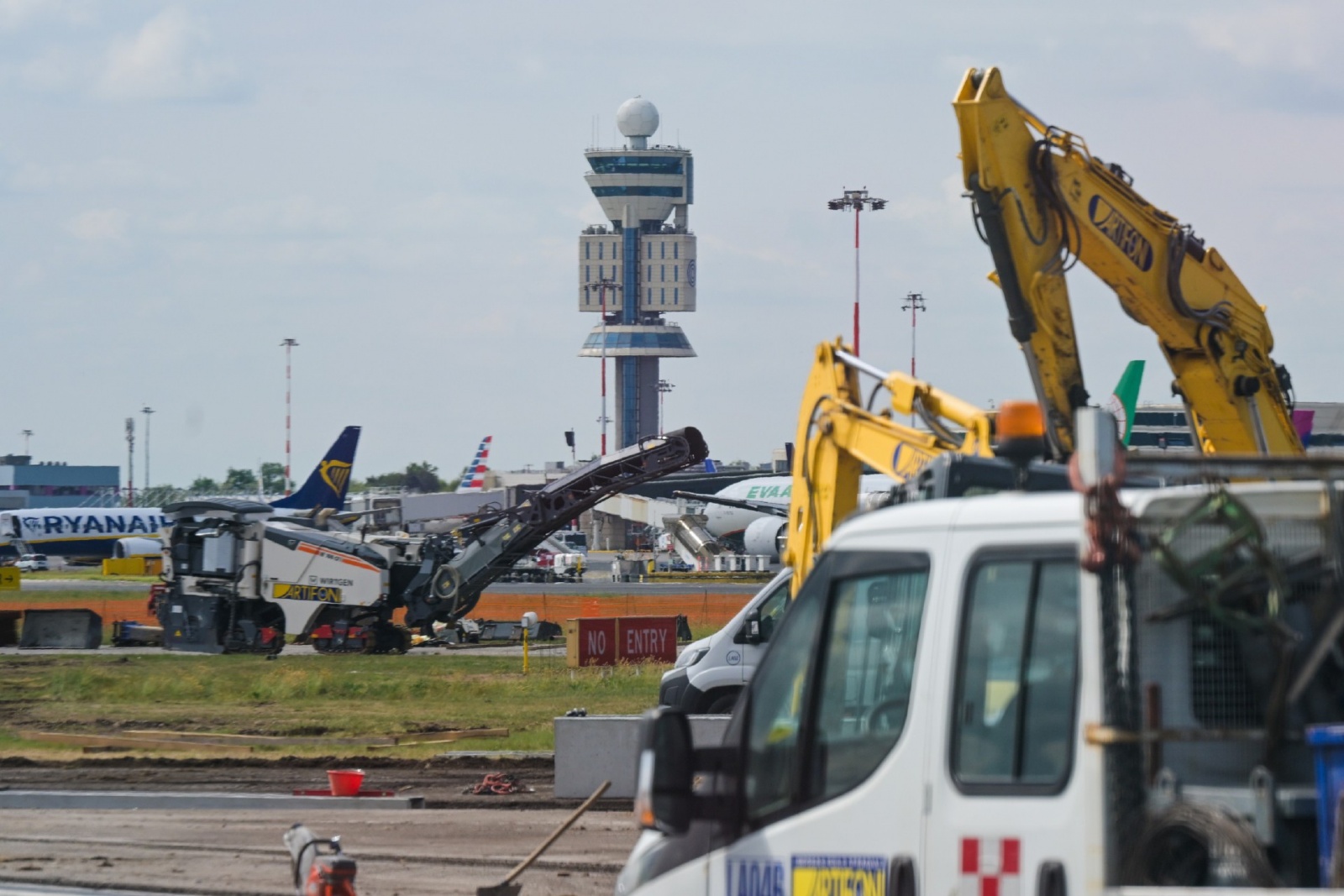 MALPENSA VISITA CANTIERE RIFACIMENTO PISTA 35L NELLA FOTO LAVORI CON SFONDO TORRE DI CONTROLLO