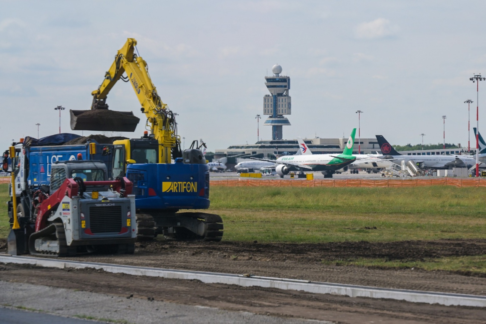 MALPENSA VISITA CANTIERE RIFACIMENTO PISTA 35L NELLA FOTO LAVORI CON SFONDO TORRE DI CONTROLLO