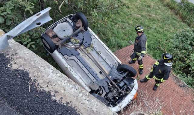 Auto sbanda e vola sul tetto di una casa